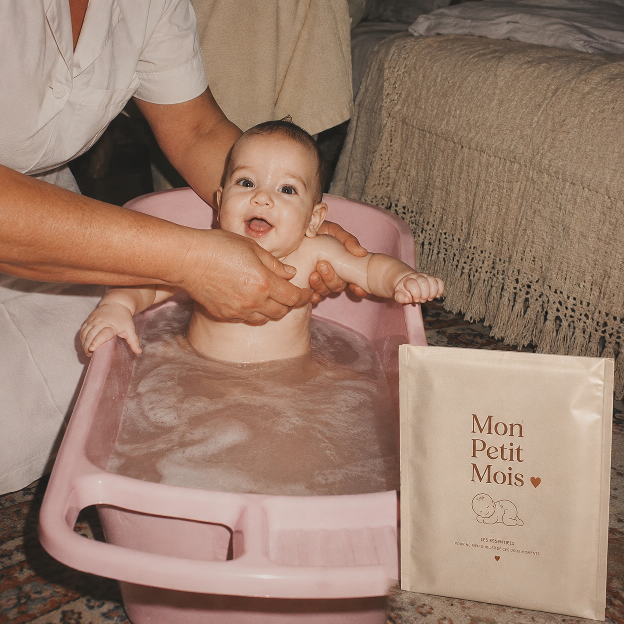 Le magazine Mon Petit Mois posé près d'un bébé pendant le bain